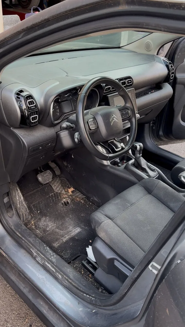 Habitacle de Citroën C4 Cactus avant nettoyage : terre et débris sur le tapis