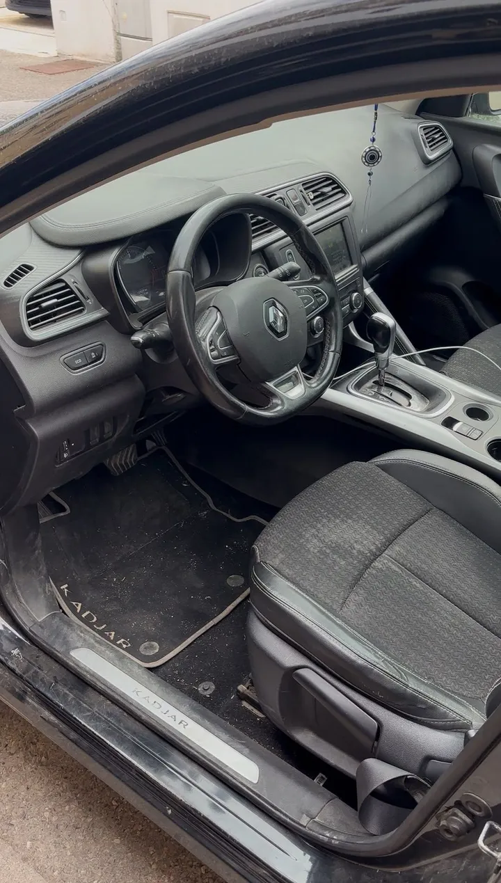 Habitacle de Renault Kadjar avant nettoyage : tapis et seuil encrassés