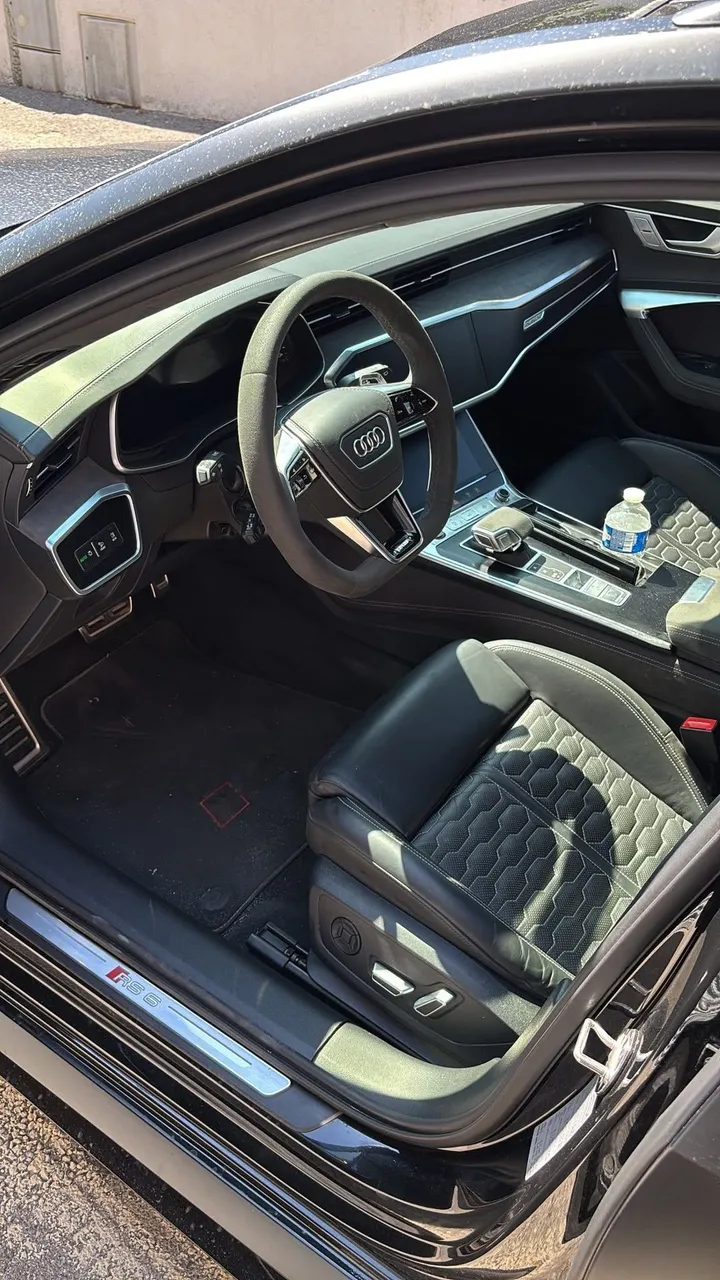 Habitacle d'Audi RS6 avant nettoyage : poussière sur la console et le tapis