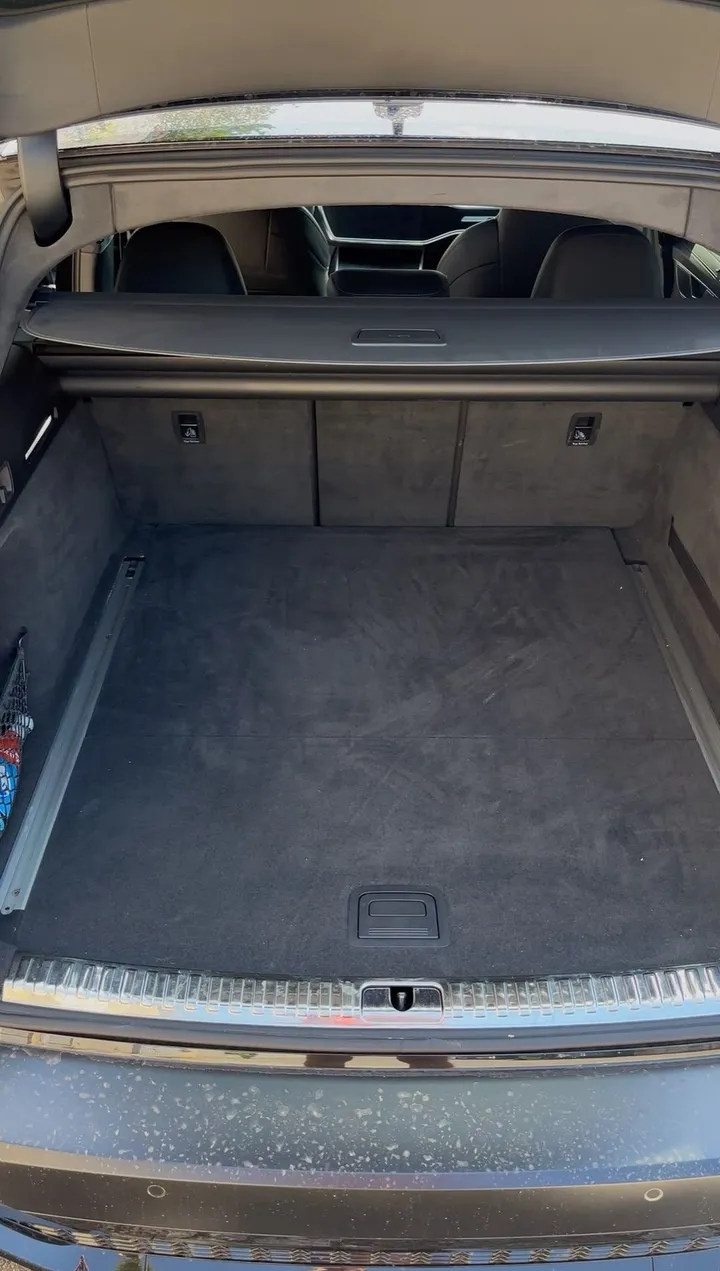 Coffre d'Audi RS6 avant nettoyage : moquette poussiéreuse
